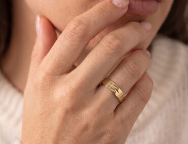 Aliança de ouro 4,5mm trabalhada com textura usada na mão feminina